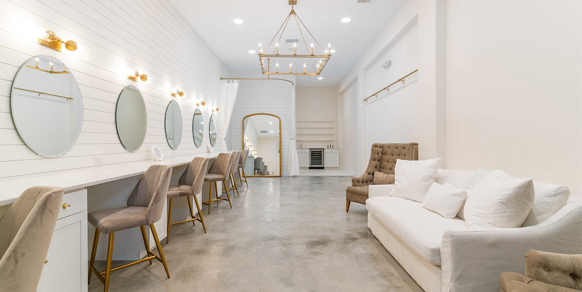 Bridal Suite Bridal suite with a white couch, arm chair and seating near mirrors.